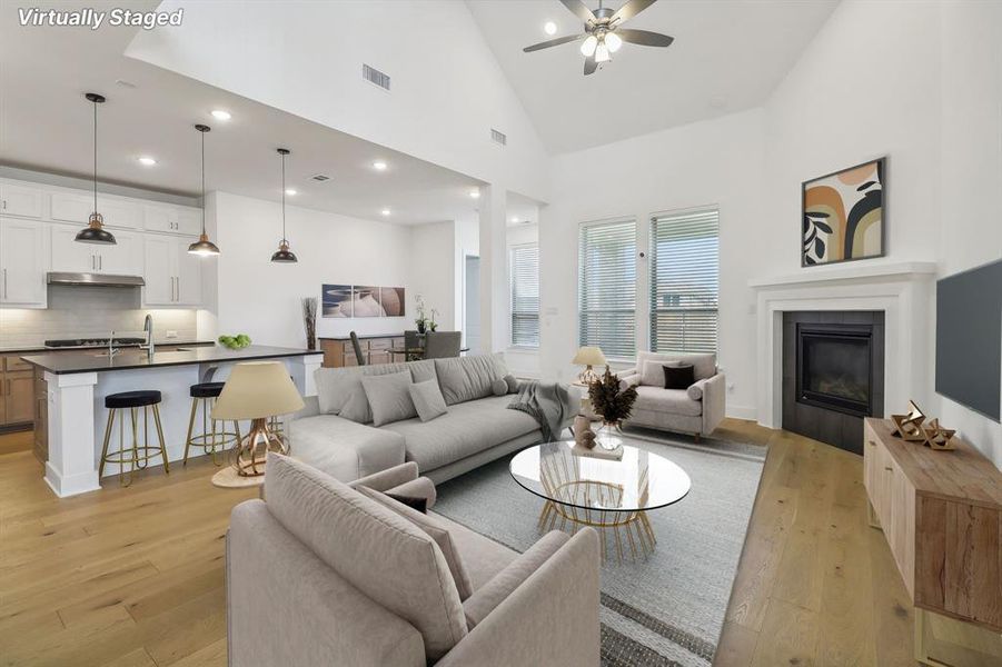 Living room with high vaulted ceiling, sink, ceiling fan, and light wood-type flooring