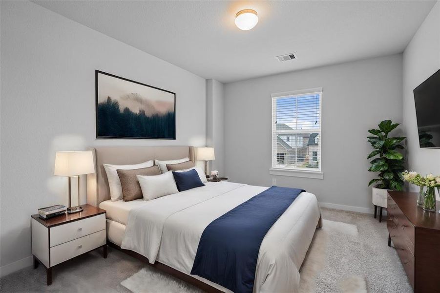 Secondary bedroom features plush carpet, neutral paint, and a large window with plenty of natural light.