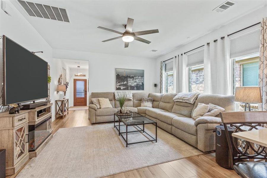 Living room featuring ceiling fan and light hardwood / wood-style flooring