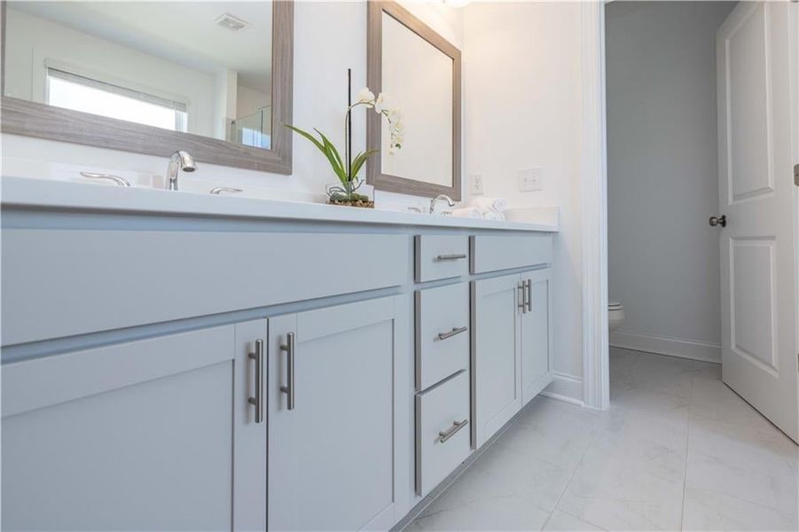 Master Bathroom with toilet, tile patterned floors, and double vanity not the actual unit