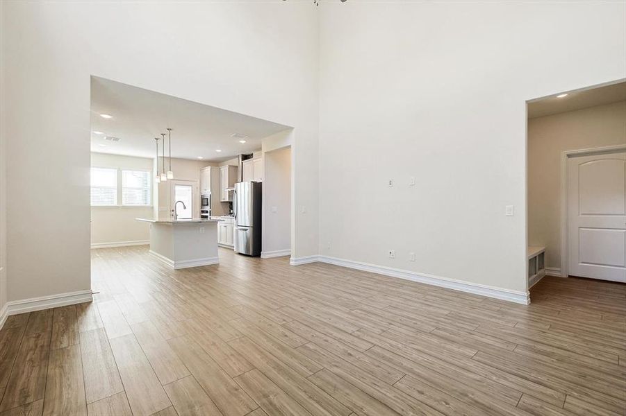 Unfurnished living room with light hardwood / wood-style flooring and an inviting chandelier