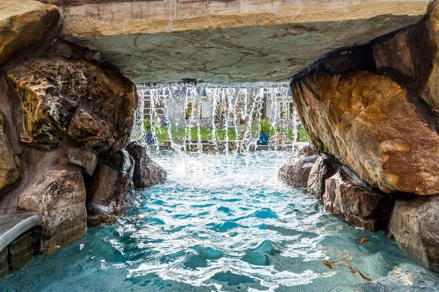 From a bench behind the swim through grotto, you can see and hear the constant waterfall that offers privacy and serenity to the entire pool area.  A home vacation spot 365 days a year!