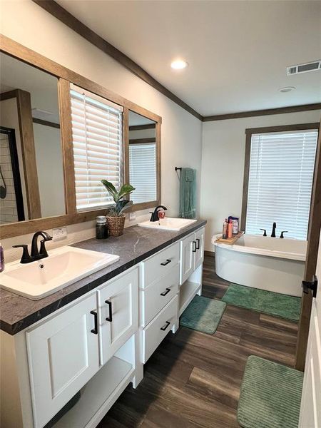 Bathroom with vanity, hardwood / wood-style floors, separate shower and tub, and ornamental molding