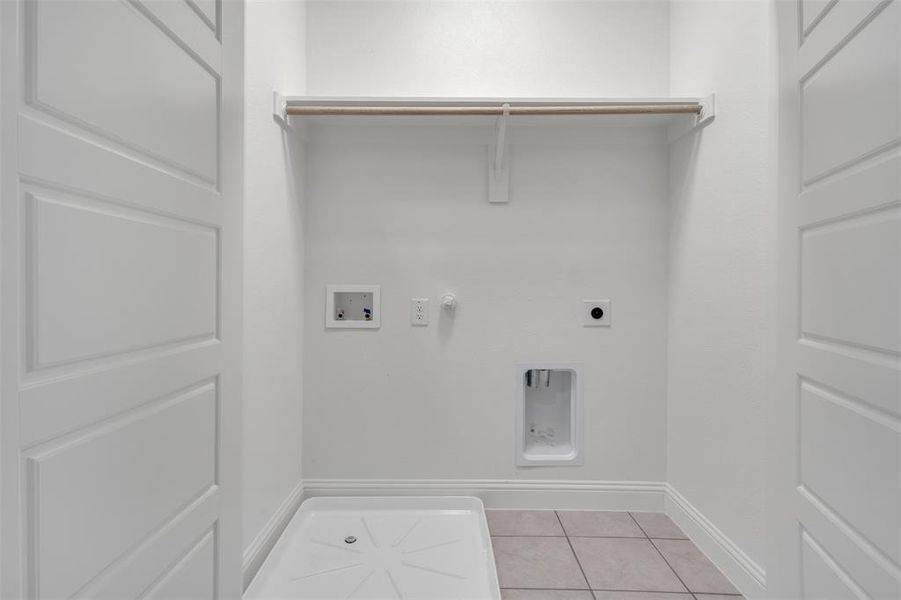 Laundry room featuring gas dryer hookup, light tile flooring, electric dryer hookup, and hookup for a washing machine