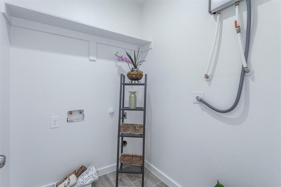 Laundry area with wood-type flooring and hookup for a washing machine