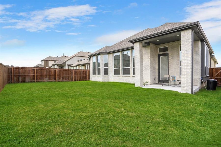 Rear view of property featuring a patio area and a lawn