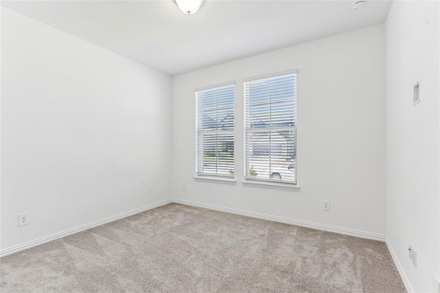 Empty room featuring light colored carpet