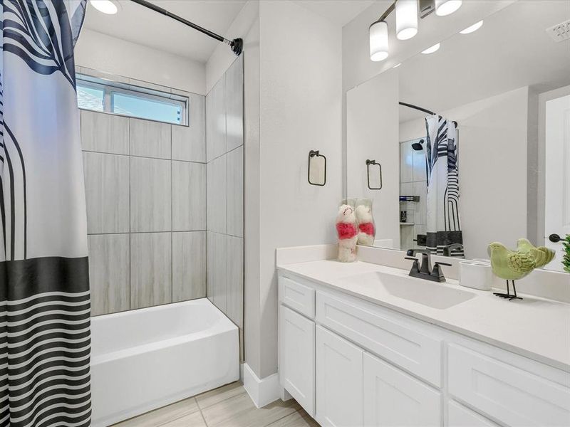 Bathroom featuring vanity and shower / tub combo with curtain