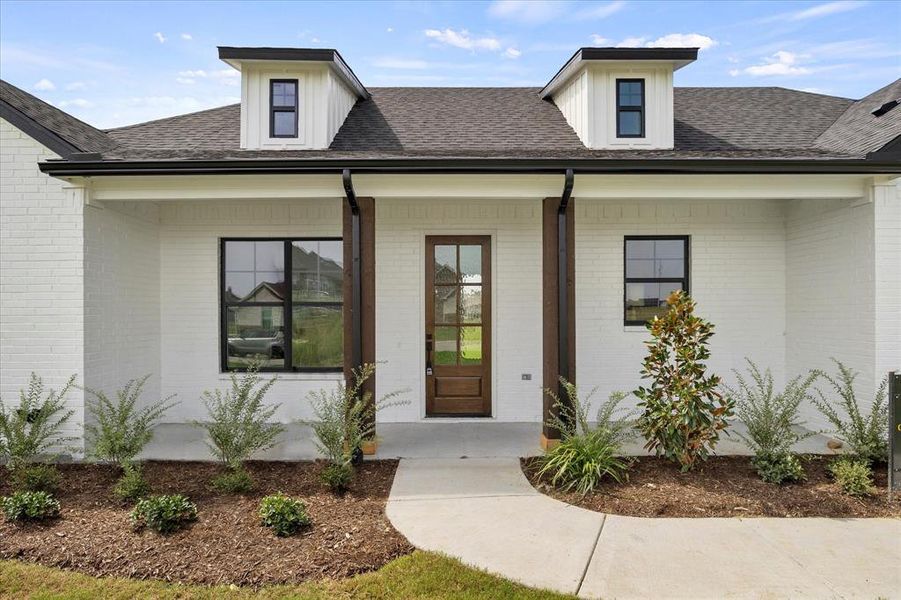 View of exterior entry with a porch