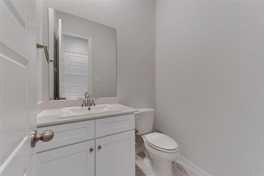 Bathroom featuring tile patterned floors, toilet, and vanity