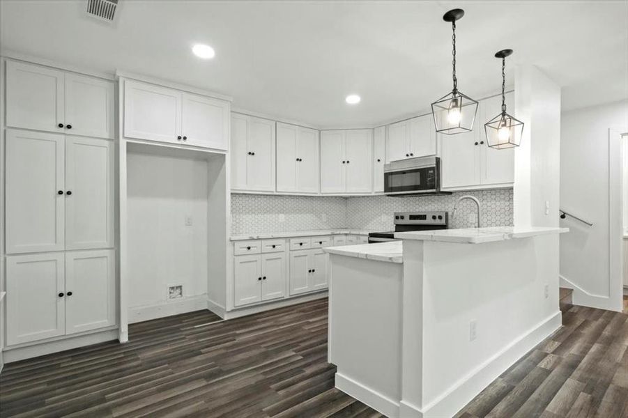 Kitchen featuring decorative light fixtures, stainless steel appliances, white cabinetry, dark hardwood / wood-style floors, and decorative backsplash