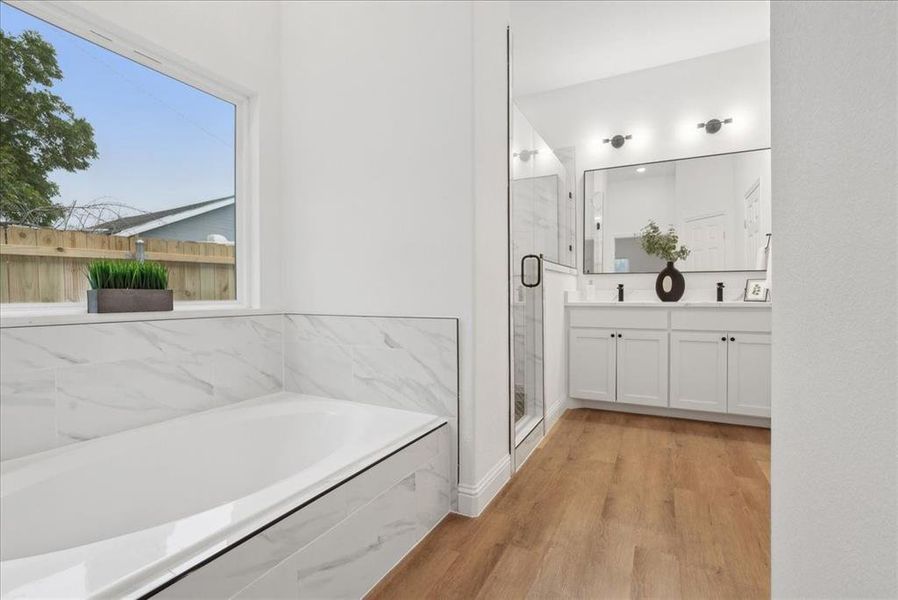 Bathroom with separate shower and tub, hardwood / wood-style flooring, and vanity