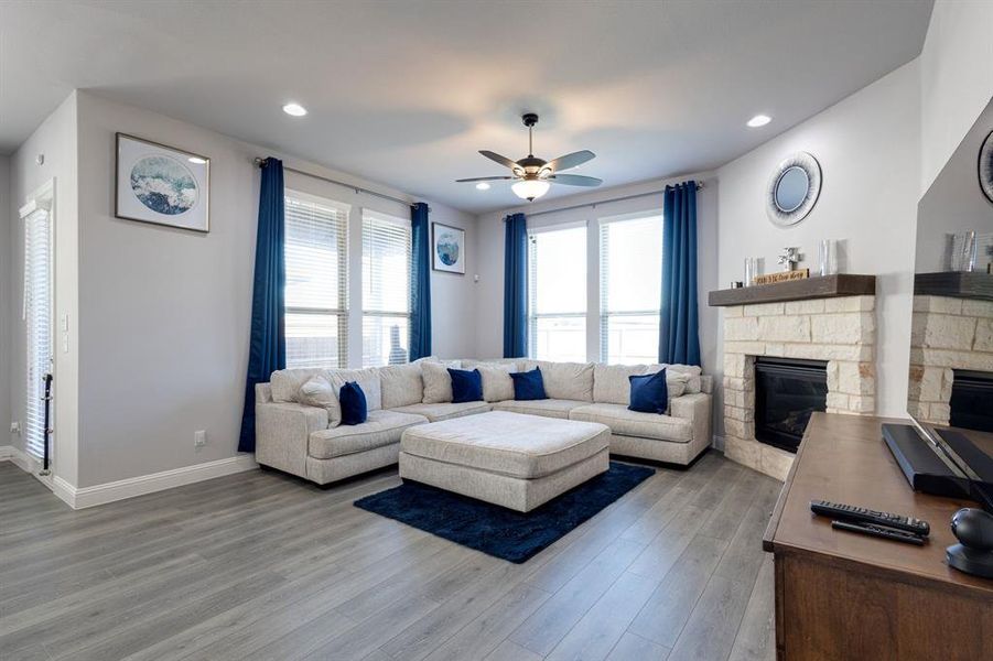 Living room featuring ceiling fan, hardwood / wood-style flooring, and a fireplace