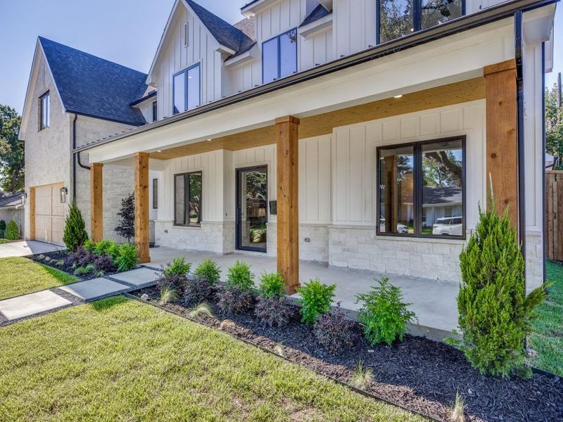 View of front facade with a garage, a porch, and a front lawn