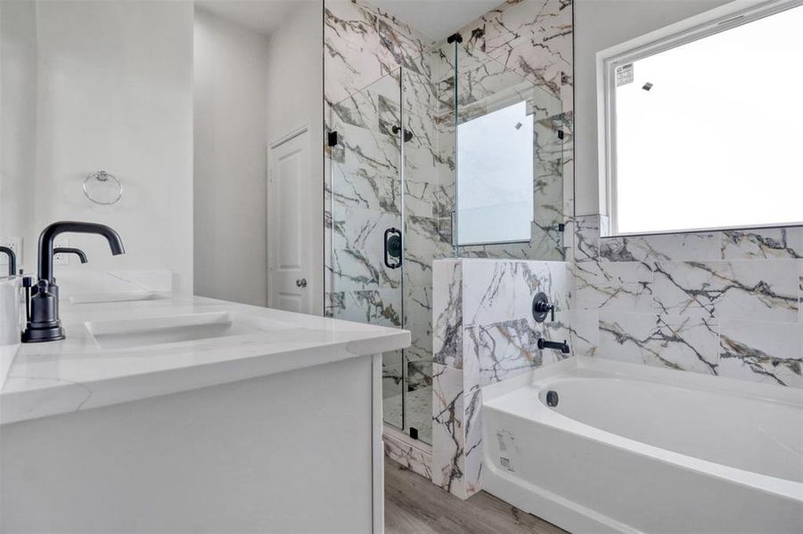 Bathroom with wood-type flooring, vanity, and plus walk in shower