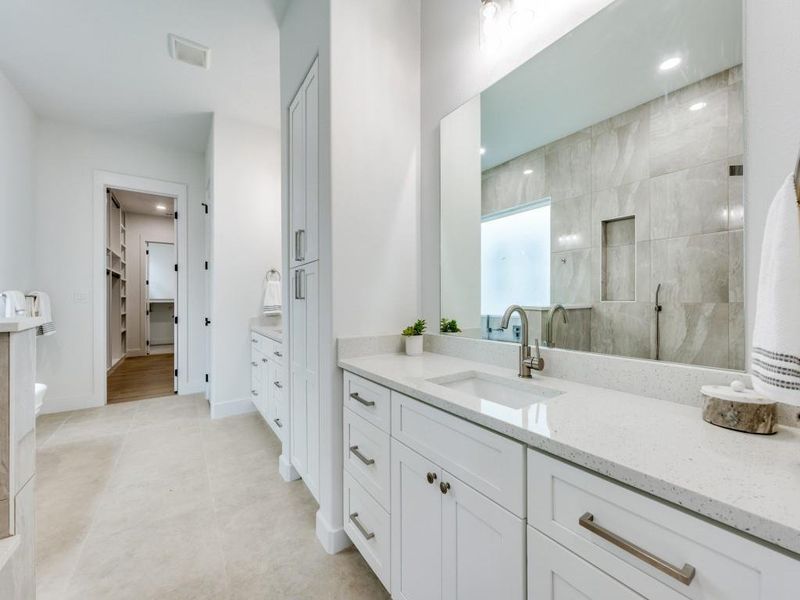 Bathroom with tile patterned flooring, vanity, and tiled shower