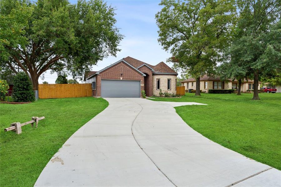 View of front facade featuring a front lawn and a garage