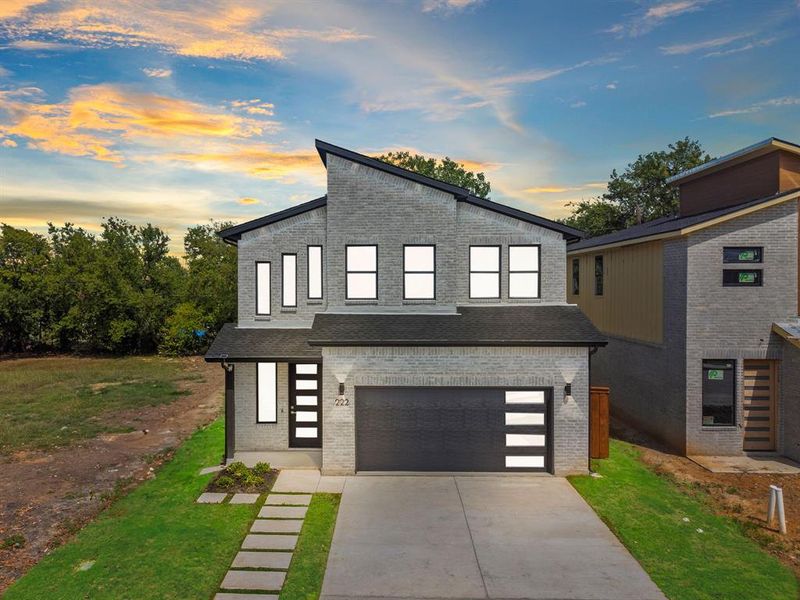 Contemporary house featuring a garage and a lawn