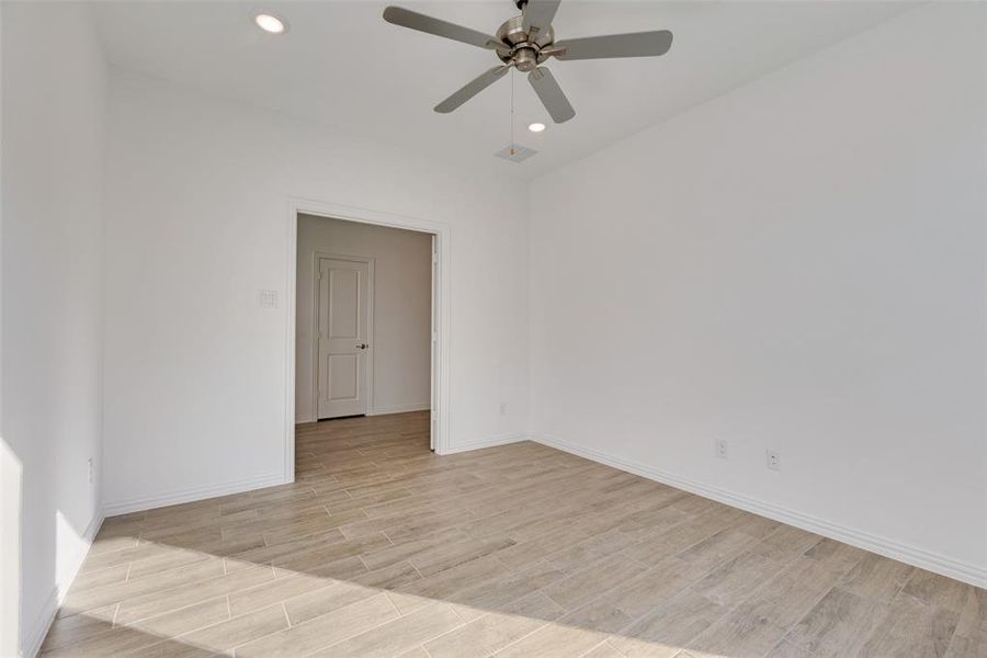 Empty room with ceiling fan and light wood-type flooring