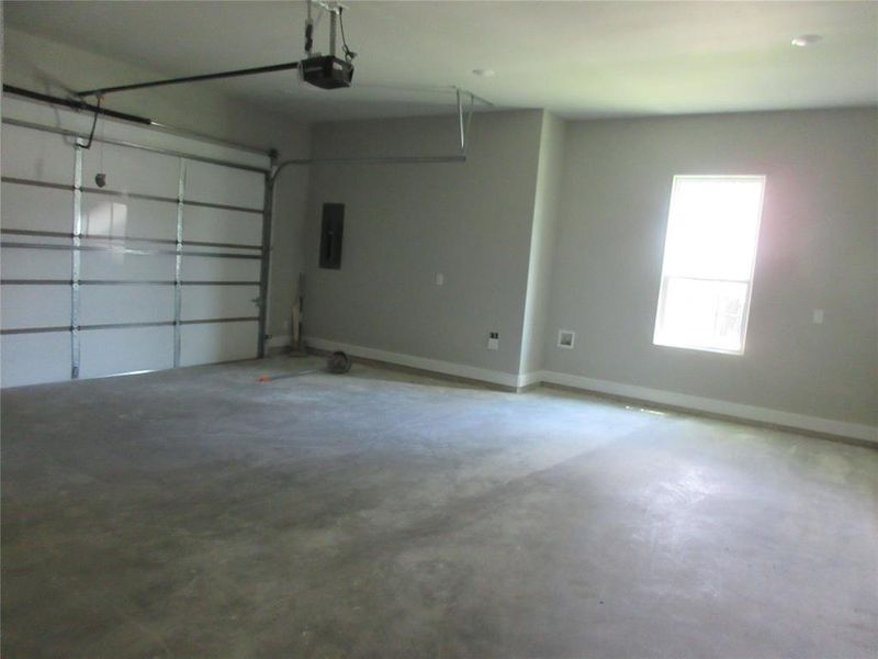 Garage featuring electric panel and a garage door opener