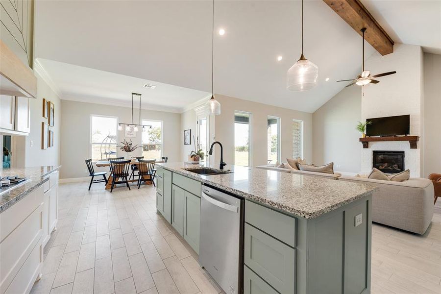 Kitchen with sink, beam ceiling, a center island with sink, ceiling fan, and stainless steel dishwasher