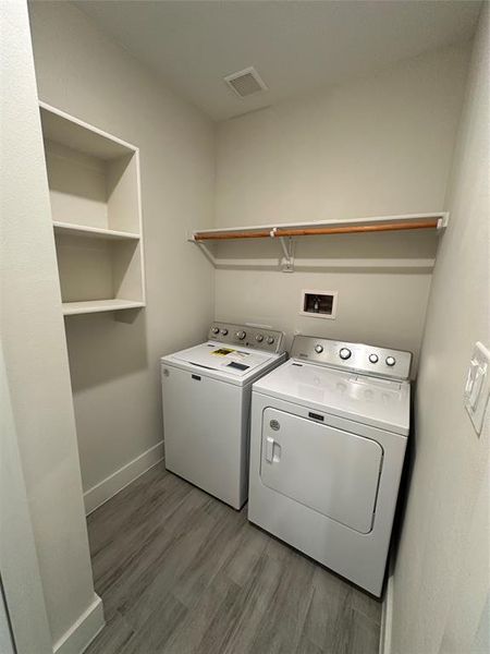 Washroom featuring washing machine and dryer, hookup for a washing machine, and hardwood / wood-style floors
