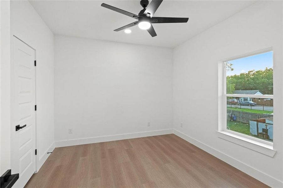Unfurnished room with ceiling fan, wood-type flooring, and plenty of natural light