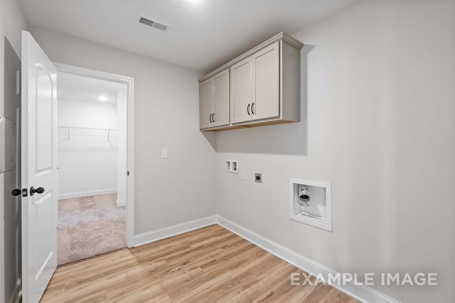 Laundry room featuring hookup for a washing machine, cabinets, hookup for an electric dryer, and light wood-type flooring