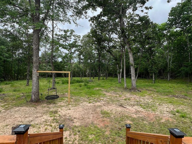 View of the back yard showcases the endless possibilities available in this neighborhood with no restrictions. Perfect for a garden, horse stable, RV pad or an additional tiny home.
