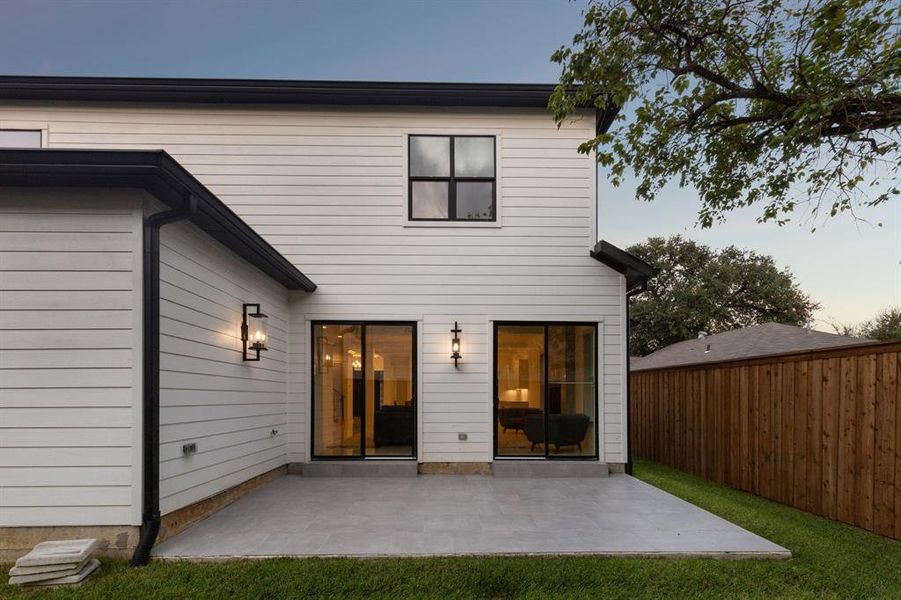 Back house at dusk featuring a patio