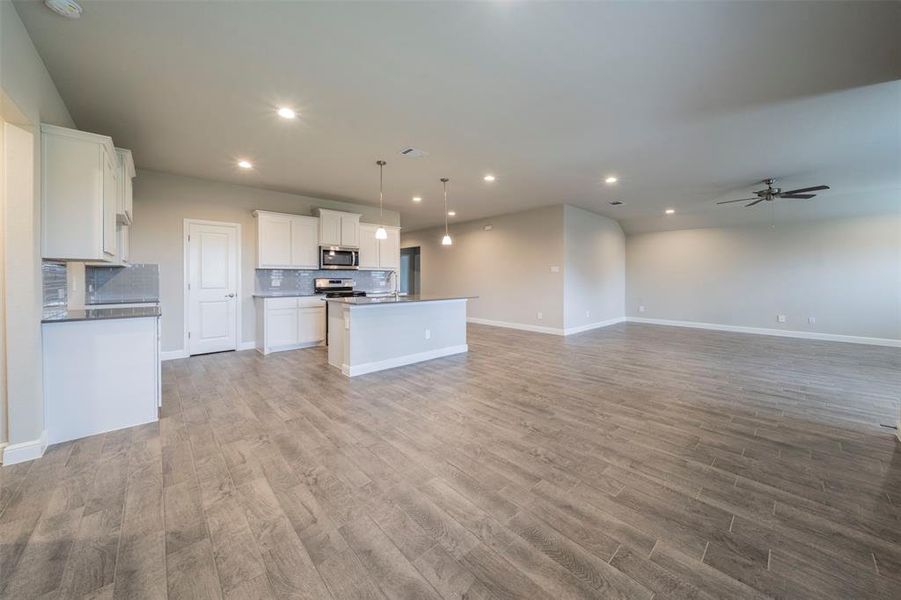 Another view of the open concept living space.  Note the canned lighting and the hanging lights over the island.