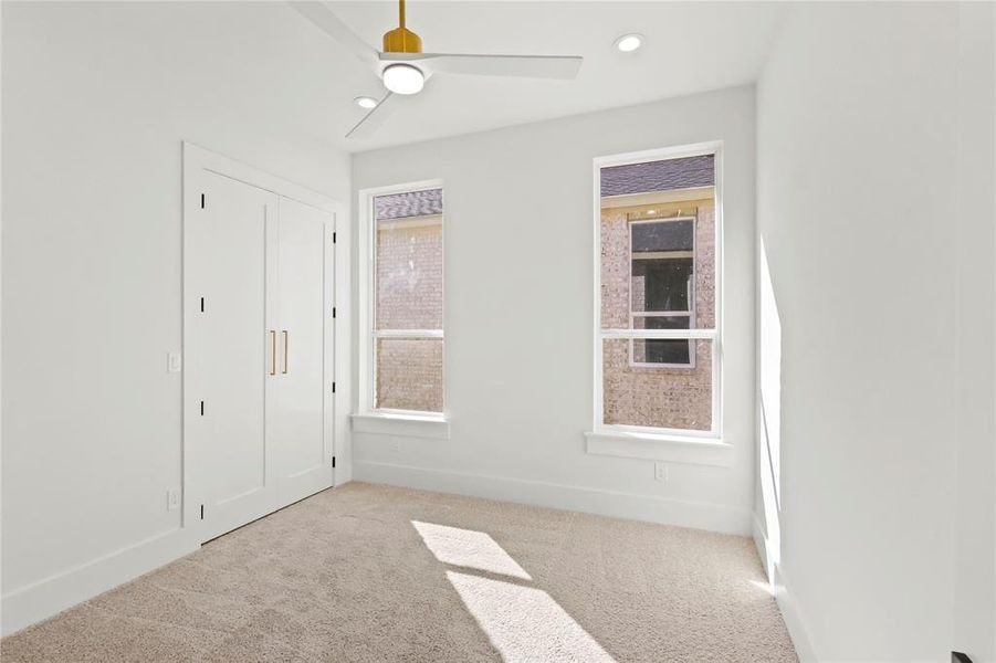 Unfurnished bedroom with a closet, light colored carpet, and ceiling fan