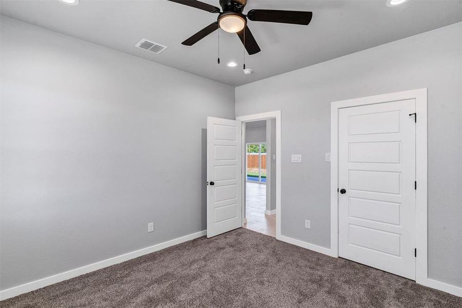 Unfurnished bedroom featuring carpet floors and ceiling fan