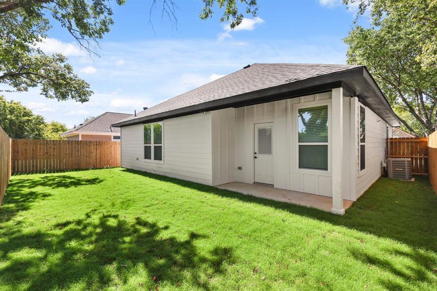 Rear view of property featuring cooling unit, a yard, and a patio area