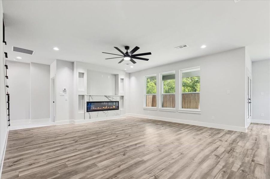 Unfurnished living room with a fireplace, and ceiling fan