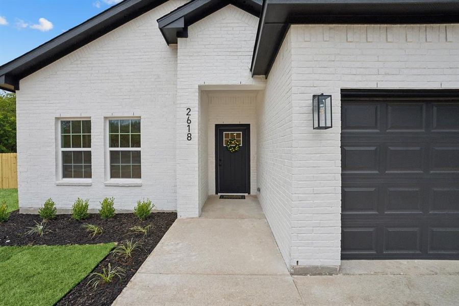 View of exterior entry with a 2 car garage