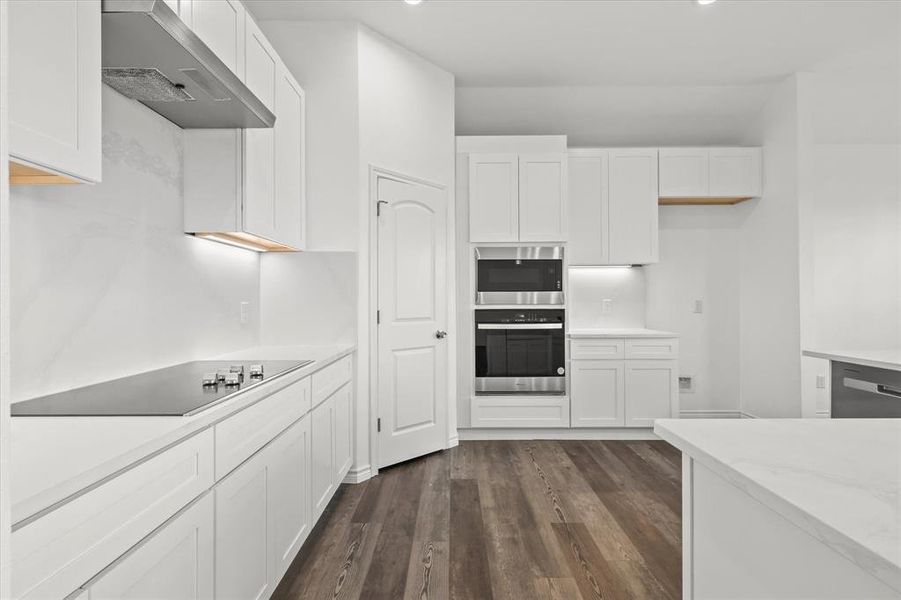 Kitchen featuring white cabinetry, wall chimney exhaust hood, dark hardwood / wood-style flooring, and black electric cooktop