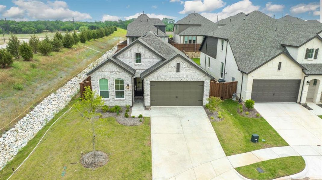 View of front of property featuring a garage and a front lawn