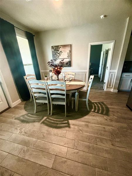 Dining room with wood-type flooring and a textured ceiling