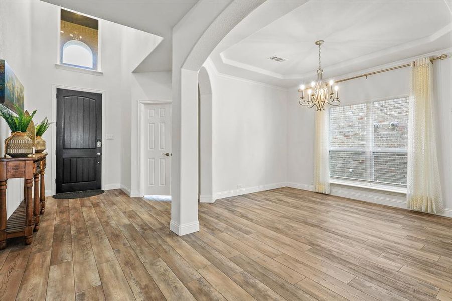 Entryway featuring a notable chandelier, light hardwood / wood-style floors, and a wealth of natural light