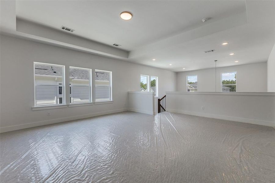 Empty room featuring a raised ceiling