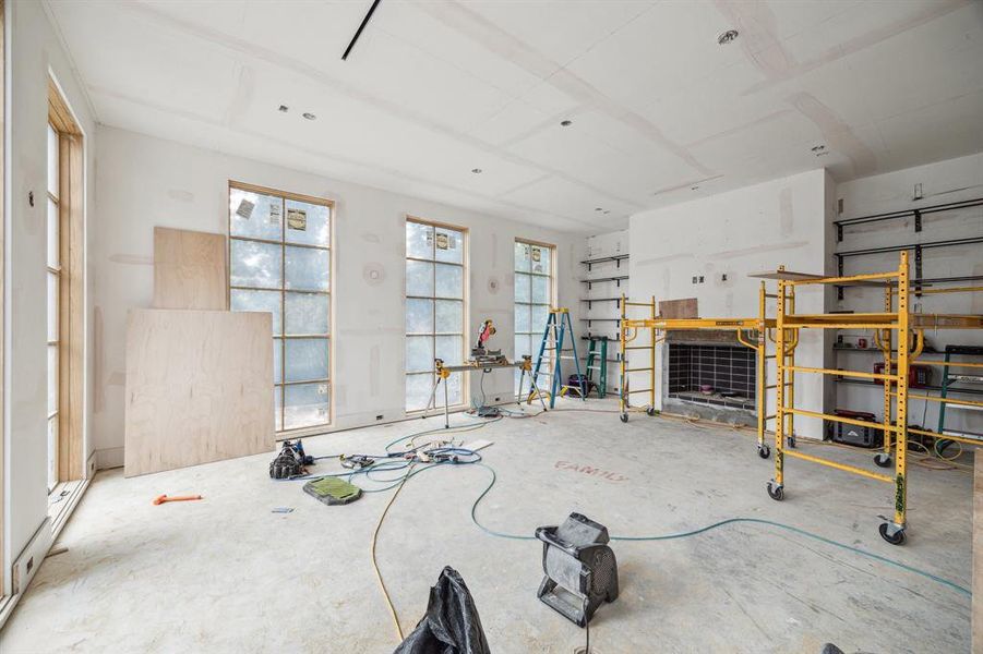 Expansive Family Room with floor to ceiling windows.  There is a Gas Log/Wood Burning Fireplace with a Venetian Plaster Wall.