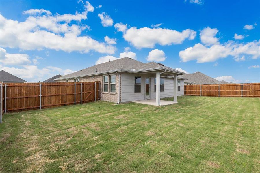 Rear view of house with a patio area and a yard