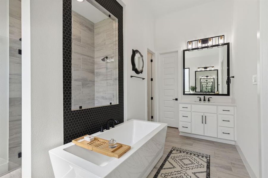 A spacious primary bathroom features a deep soaking tub perfect for relaxation, complemented by a separate glass-enclosed shower for everyday convenience.