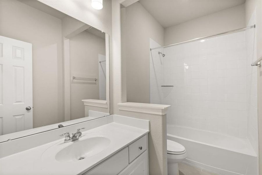 The secondary bath features tile flooring, white cabinetry and light countertops and a shower/tub combo. Perfect for accommodating any visiting family and friends.