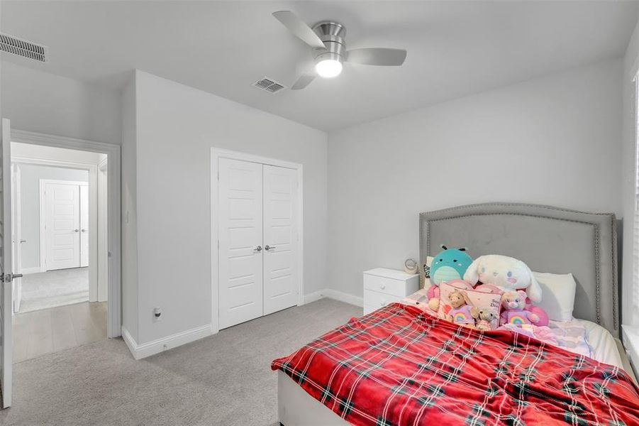 Bedroom with a closet, carpet, and ceiling fan