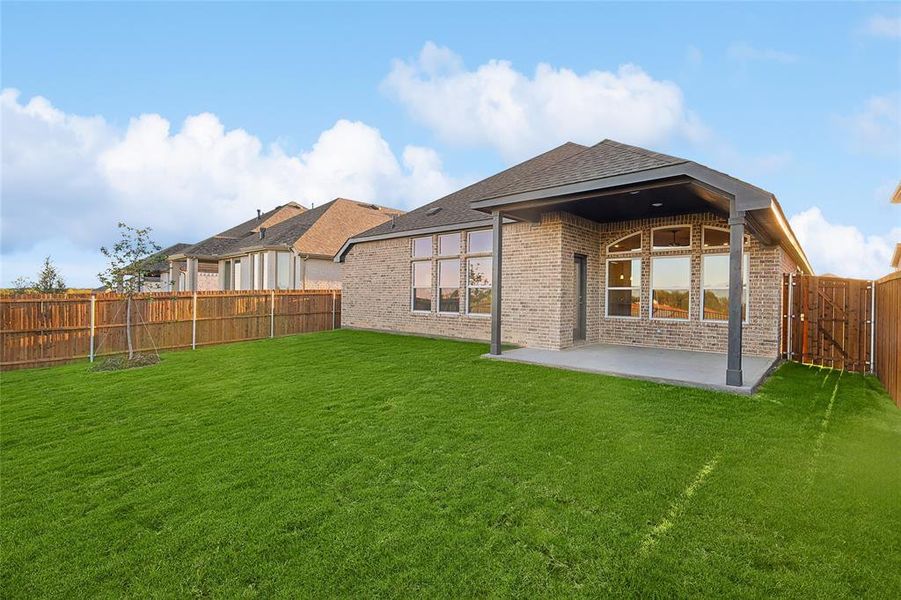 Back of house with a lawn and a patio area