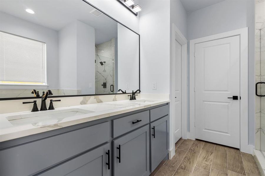 Bathroom with vanity, wood-type flooring, and a shower with shower door