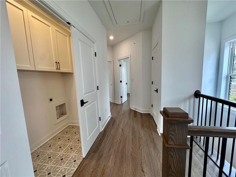 Laundry room, cabinets, located directly outside the owners and separating the two additional guest bedrooms