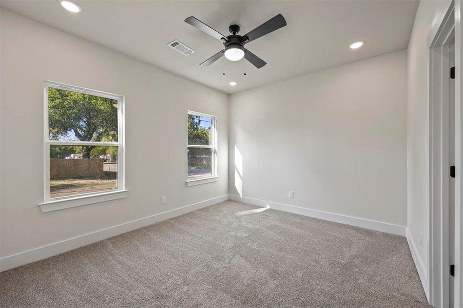 Carpeted empty room featuring ceiling fan